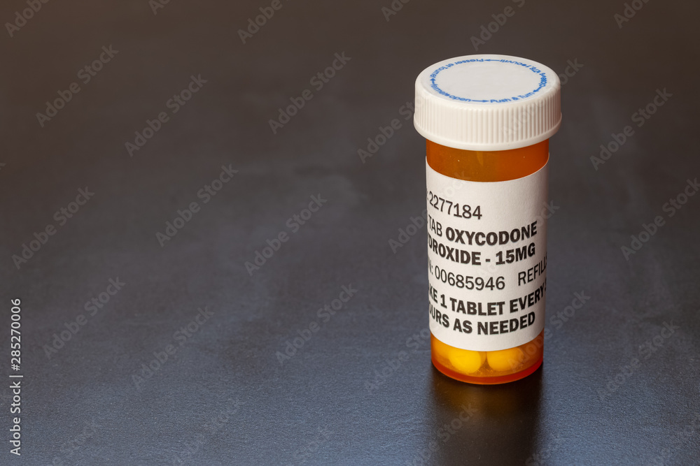 Prescription bottle with backlit Oxycodone tablets. Oxycodone is a ...