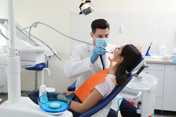 Wall Mural - Professional dentist working with patient in clinic