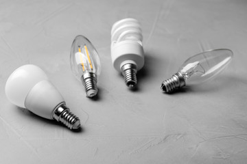 Different lamp bulbs on grey stone background