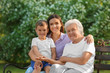 © New Africa - Grandmother with her family sitting on bench in park