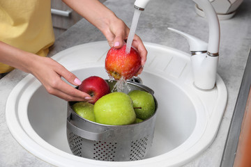 Sticker - Woman washing fresh apples in kitchen sink, closeup