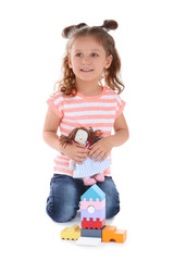 Wall Mural - Cute little girl playing with toys on white background