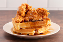 Pile of Chicken and Waffles on a Rustic Wooden Counter