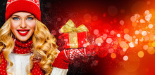 Smiling And Happy Blond Woman With Christmas Gift Box On Red Background. Girl Celebrates New Year 2020 In Winter. Shopping Black Friday Sale Concept For Shop.