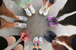 © New Africa - Young people making circle and showing their sports shoes outdoors, above view
