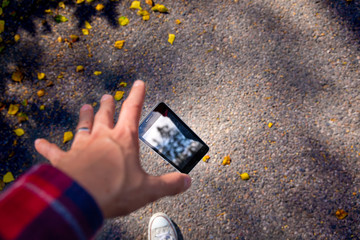 Man dropping his smartphone ad trying to reach it. Phone screen is cracked and needs repairing. Great photo to advertise smartphone repair shop, screen repair or water damage. 