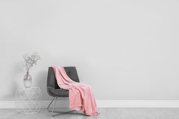 Wall Mural - Stylish room interior with comfortable chair and plaid near white wall. Space for text