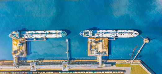 Wall Mural - Aerial top view wide panorama of the oil terminal and two moored tankers with liquid fuel loaded on the pier, railway tank cars for loading and unloading.