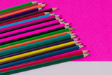 Fototapeta Tęcza - Many colored pencils lie on a white-pink background. Copy spase. The concept of back to school, the educational process, study at school, drawing