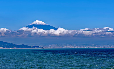 Wall Mural - Sea approach to Shimizu, Japan with the snow capped peak of the iconic Mt. Fuji gleaming above low clouds