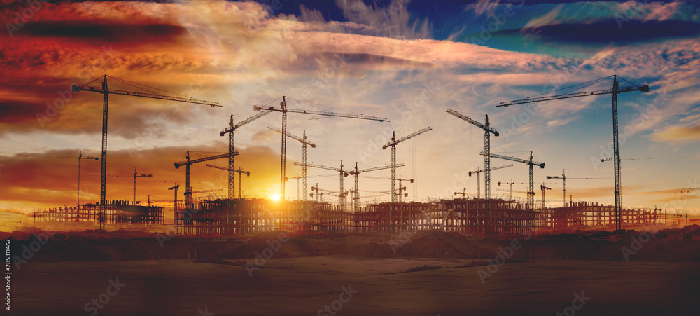 Gruas de construcción y puesta de sol.Concepto de industria y mercado inmobiliario..Cimientos de bloque de pisos - obrazy, fototapety, plakaty 