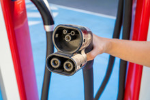 Oslo, Norway - August 20, 2019: Woman Hand Holding Plug In Connector For Charging Electric Car. Charging An Electric Car With The Power Cable Supply Plugged In.Eco Energy Concept