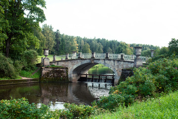 old vintage bridge on river in green park, landscape historical