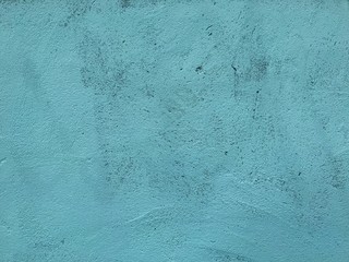 Background of Grunge chipped, distressed concrete wall sloppy painted with a light turquoise paint