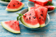 © Beton Studio - Close-up of fresh red watermelon slices in blue plate on an blue rustic wooden background.