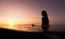 Surfer Girl Waiting In The Line Up For A Wave At Sunrise Or Sunset