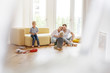 © Westend61 - Happy family with two sons playing in living room of their new home