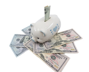 A white piggy bank against a white background watches over a pile of United States currency. Wealth, Savings, inflation concept - image