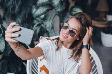 Wall Mural - young pretty woman posing in the street with phone, outdoor portrait, hipster girls, sisters, chic, tablet, internet, using smartphone, close-up fashion model, post in instagram, facebook