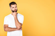 © LIGHTFIELD STUDIOS - thoughtful handsome man in white t-shirt isolated on yellow with copy space
