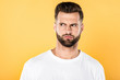 © LIGHTFIELD STUDIOS - worried handsome man in white t-shirt looking away isolated on yellow