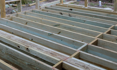 A new wooden, timber deck being constructed. it is on the decking.