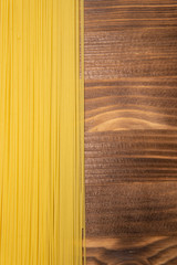 Poster - raw spaghetti pasta scattered on wooden table