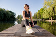 © fotofabrika - Attractive woman practicing yoga on a mat on a pier near the lake in the morning