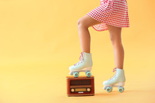 Beautiful Young Woman On Roller Skates And With Retro Radio Receiver Against Color Background