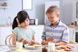 © Pixel-Shot - Funny little children eating tasty toasts in kitchen