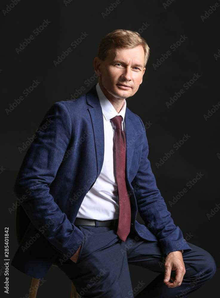 Portrait of handsome businessman on dark background