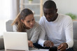 © fizkes - Interracial couple using calculator calculating paying domestic bills do paperwork