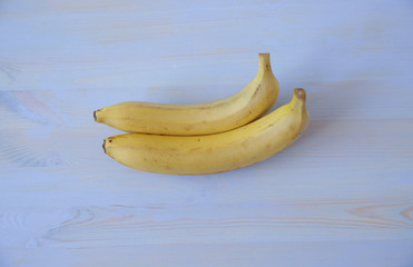 yummy ripe two bananas isolated on a blue wooden background. Healthy food. With copy space for text or image. Flat lay.