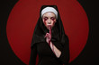 Satanic nun with bloody scar on face. Horror halloween concept. Sister prays with closed eyes