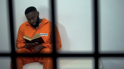 African-american prisoner reading holy bible, convicted sinner, religion