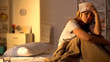 © motortion - Sick lady with towel on forehead suffering from migraine, sitting in bed at home