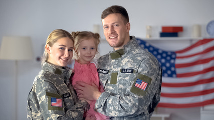 Wall Mural - Happy american military couple with child smiling on camera, patriotic family