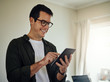© StratfordProductions - Smiling man using digital tablet at home