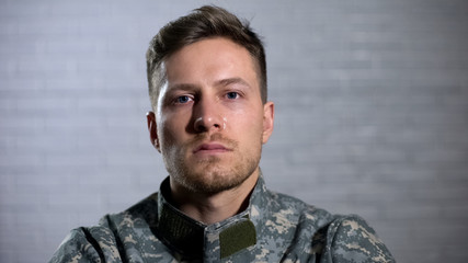 Crying male soldier looking at camera, military posttraumatic syndrome, problem