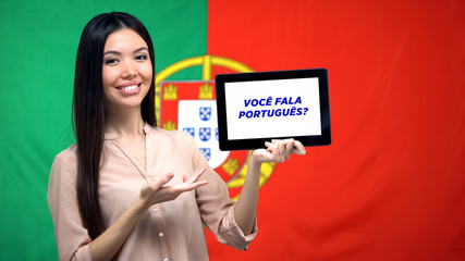 Woman holding tablet with do you speak portuguese phrase, app learning language