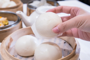 Wall Mural - Delicious dim sum, famous cantonese food in asia, fresh and hot salted creamy custard buns in bamboo steamer in hong kong yumcha restaurant, close up