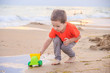 © alenka2194 - A boy plays a typewriter on the beach. Children's games. Beach in the summer. Small child