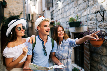 Wall Mural - happy group of friends tourists sightseeing in city on vacation