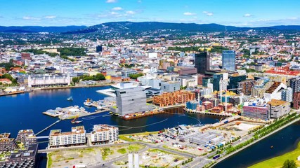 Wall Mural - Oslo, Norway. Aerial view of Sentrum area of Oslo, Norway, with Barcode buildings and the river Akerselva. Construction site with blue sky. Time-lapse with car traffic, panning video