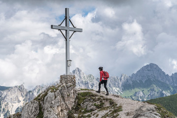 Wall Mural - nice and active senior woman approaching the summit of Litnis Schrofen during a bike and hike adventure in the Tannheim Valley, Tirol Austria