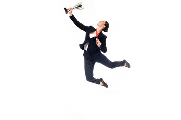 young businesswoman with medal and trophy cup jumping in dance isolated on white