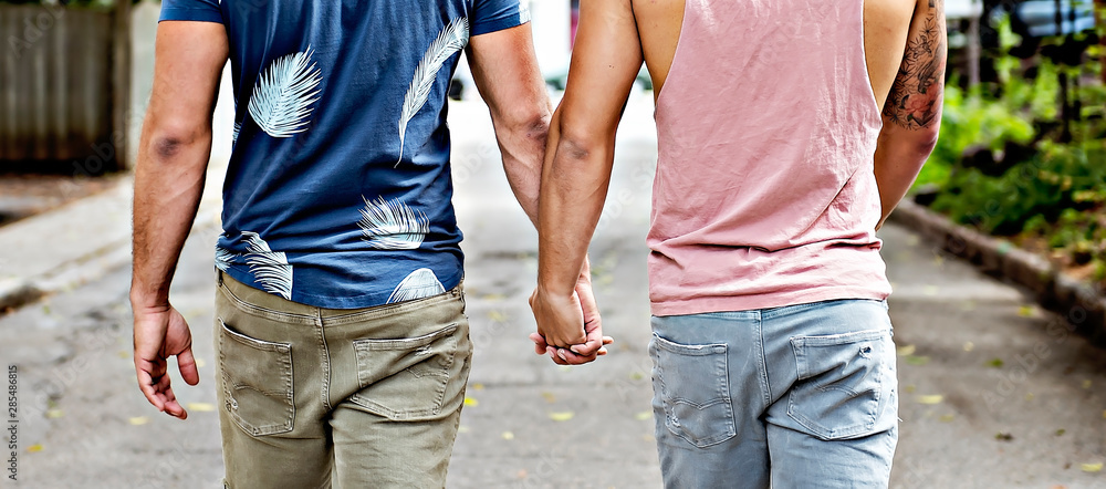 A Portrait of a happy gay couple outdoors in urban background - obrazy, fototapety, plakaty 