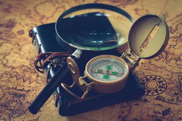 old map with compass, notebook and magnifying glass. the concept of searching for interesting places