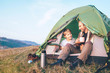 Father and son sit in camp tent drink hot tea and have conversation. Leisure time with father, parenthood
