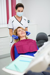 Wall Mural - young female dentist with happy mature woman patient at clinic